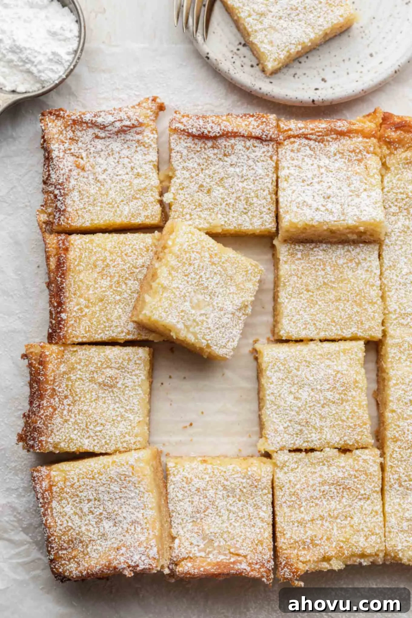 Golden Gooey Delight 2 An overhead view of a sliced gooey butter cake, with one slice resting on another.