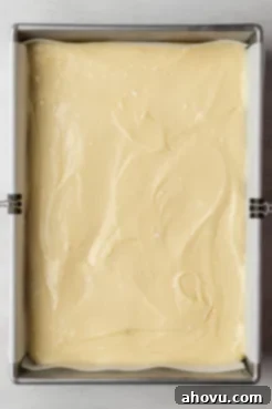 An overhead view of an unbaked gooey butter cake in a baking pan.