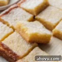 Golden Gooey Delight 6 Several sliced gooey butter bars on a piece of brown parchment paper.