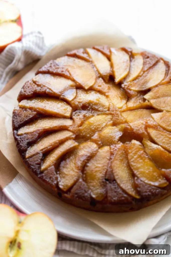 A close up image of a freshly baked apple upside-down cake, beautifully showcasing its rich caramelized apple topping.