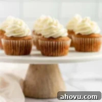 Pumpkin cupcakes sitting on top of a marble cake stand.