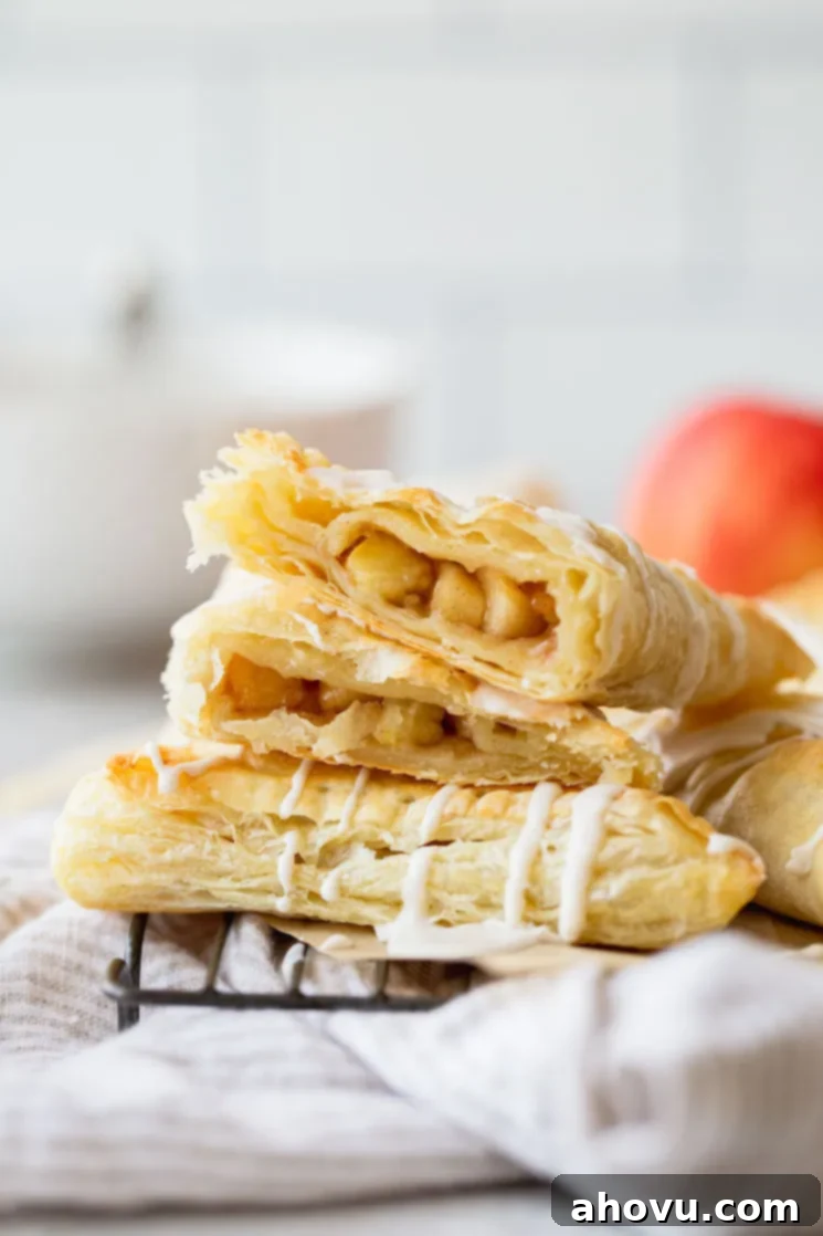 Flaky Apple Delights 2 A stack of apple turnovers with one cut in half showing the apple filling.