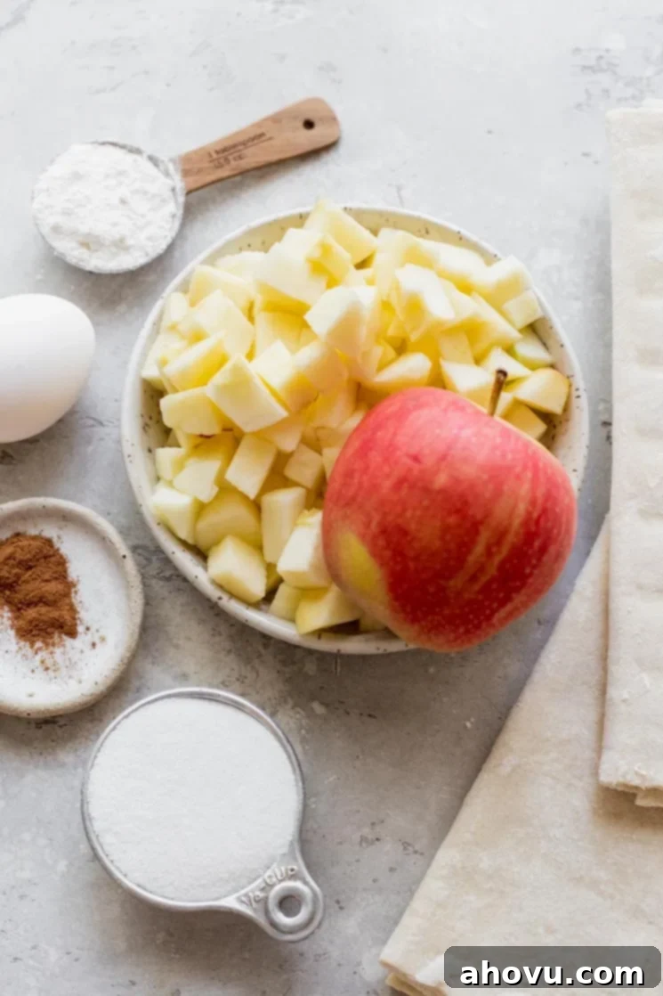 Flaky Apple Delights 3 The ingredients for apple turnovers sitting on top of a rustic gray surface.