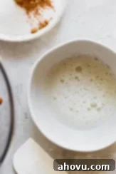 An egg white in a bowl mixed with water until frothy, ready to coat the pecans.
