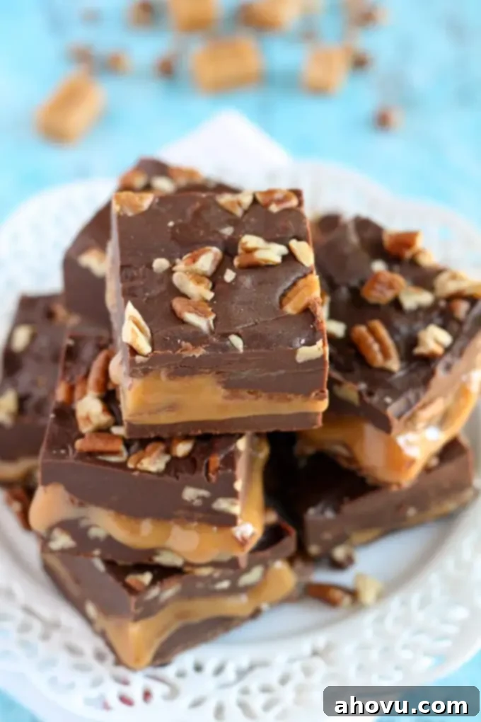 Rich chocolate fudge with a luscious caramel center and crunchy pecans, ready to be sliced.