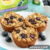 Berry Bliss Baked Oats 5 Three healthy blueberry baked oatmeal cups on a white plate with fresh berries.