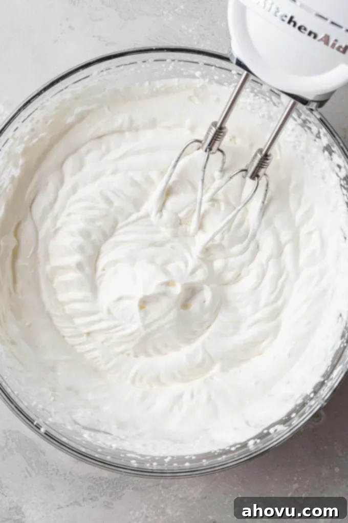 Decadent No-Bake Oreo Cheesecake 6 An overhead view of freshly whipped cream in a mixing bowl, showing stiff peaks.