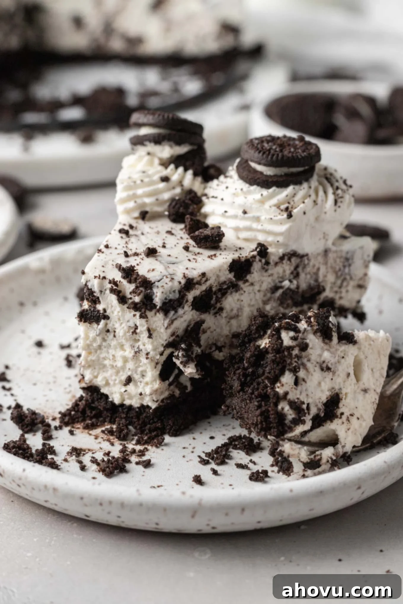 Decadent No-Bake Oreo Cheesecake 10 A slice of no-bake Oreo cheesecake, with a bite taken out, showing its fluffy filling and rich crust.