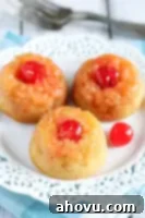 Caramelized Pineapple Mini Cakes 5 A top-down shot of a single mini pineapple upside-down cake, revealing its golden caramelized topping and vibrant maraschino cherry.