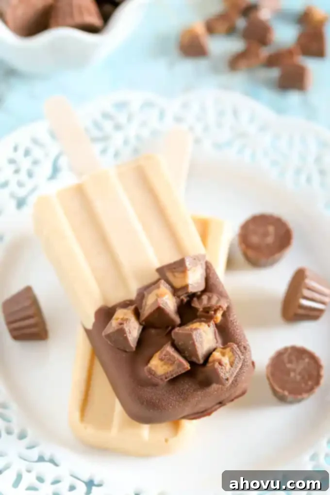 Close-up of a Peanut Butter Cup Pudding Pop, showcasing the creamy peanut butter base, chocolate magic shell, and chopped mini peanut butter cups