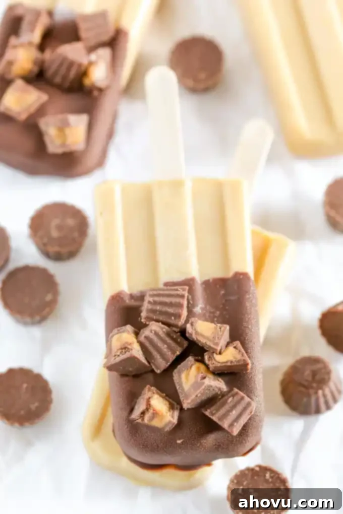 Peanut butter popsicles with chocolate magic shell and mini peanut butter cups, stacked delightfully as a delicious and easy summer treat