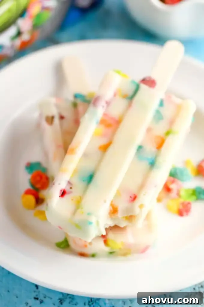 A freshly removed Marshmallow Fruity Pebbles pudding pop with visible cereal pieces.