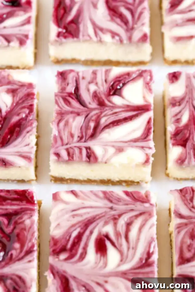 A close-up of a homemade blackberry swirl cheesecake bar on a white plate, showcasing the smooth creamy filling and vibrant fruit swirl.