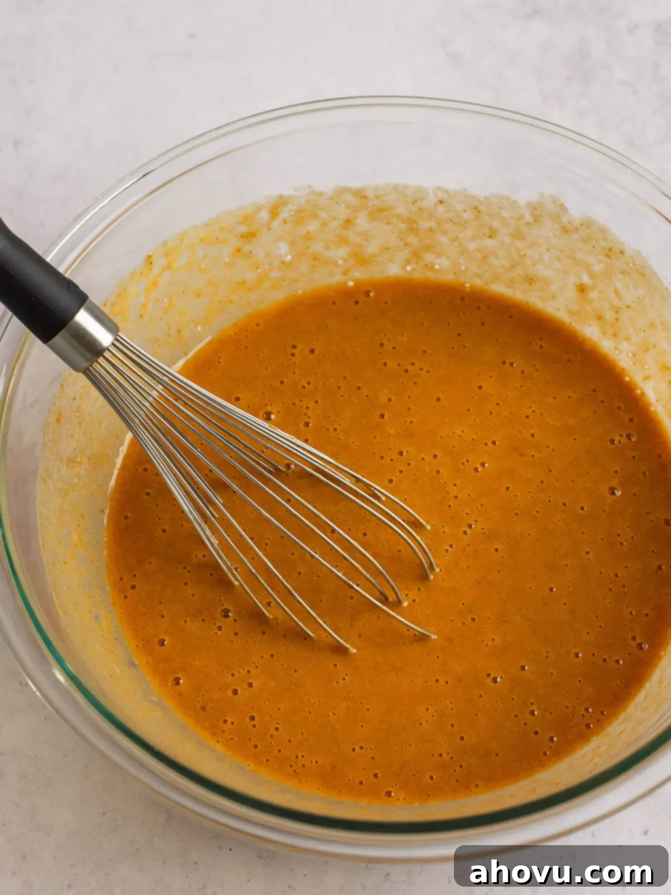 Spiced Pumpkin Perfection 13 Smooth and perfectly combined pumpkin pie filling resting in a clear glass mixing bowl, ready to be poured into the crust.