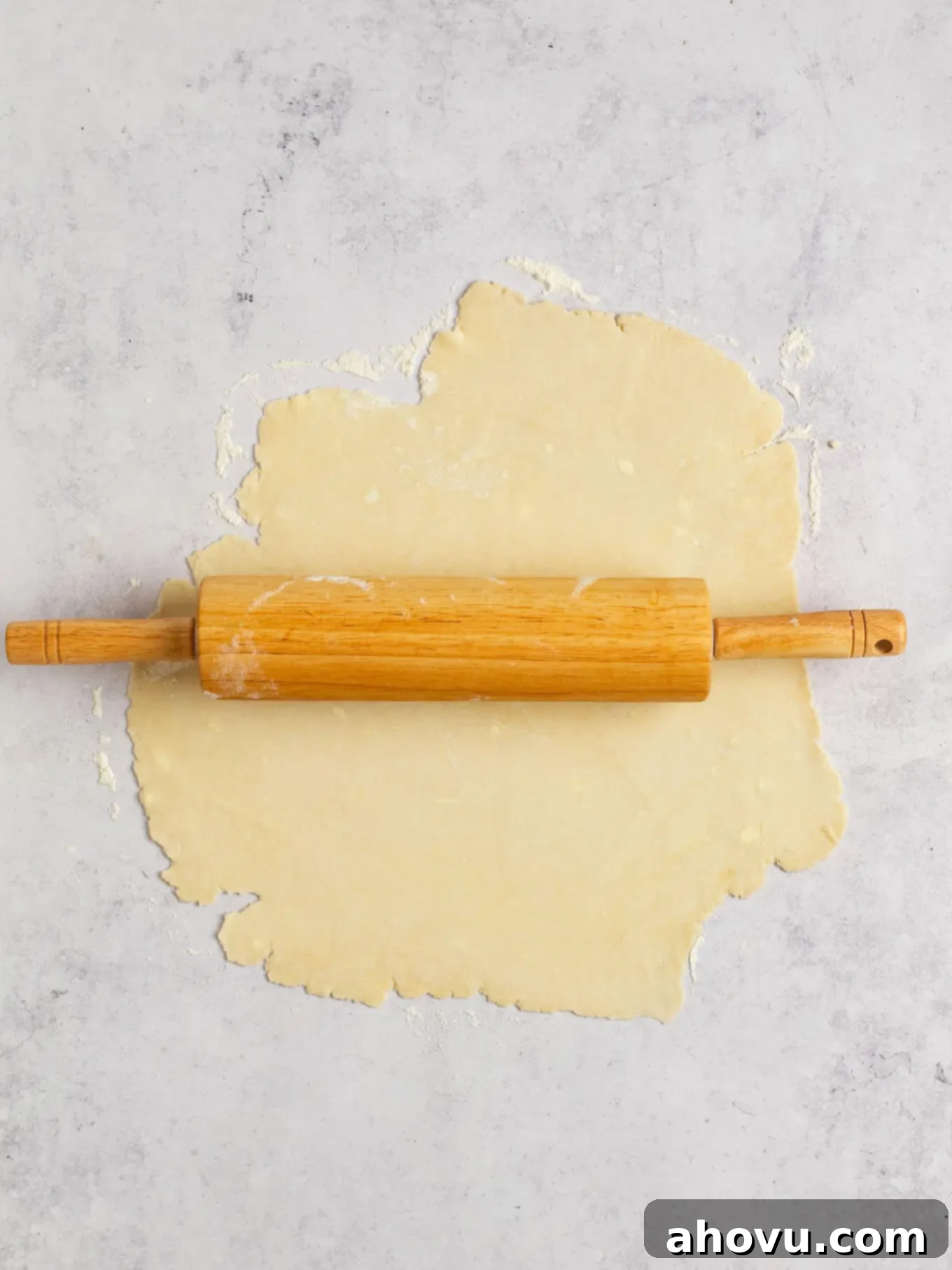 Spiced Pumpkin Perfection 4 Flaky pie dough neatly rolled out on a clean gray kitchen surface, ready for transfer to a pie dish.