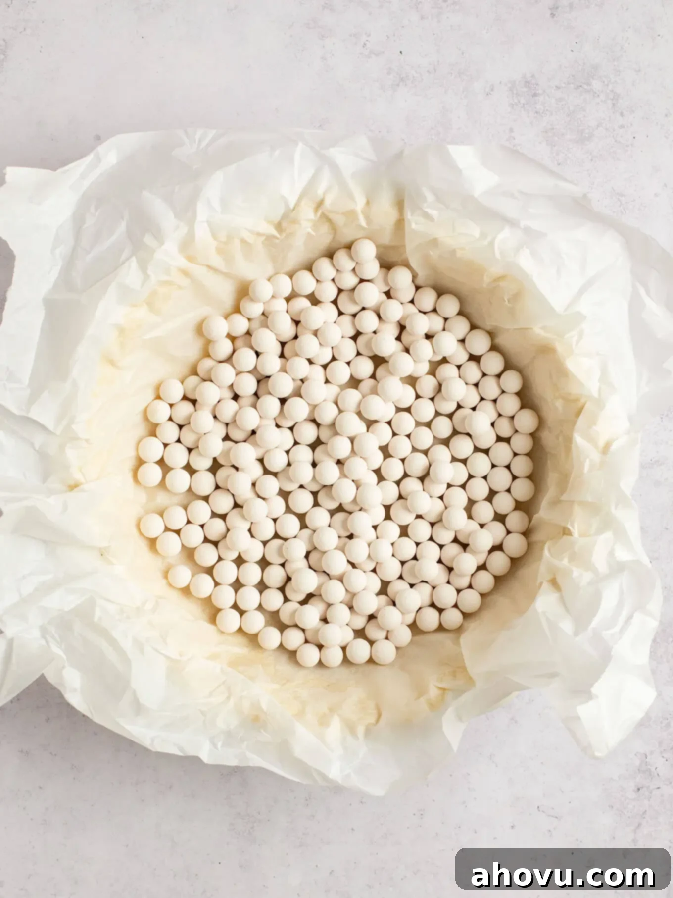 Spiced Pumpkin Perfection 9 A raw pie crust, expertly lined with parchment paper and weighted down with pie weights, ready for blind baking.