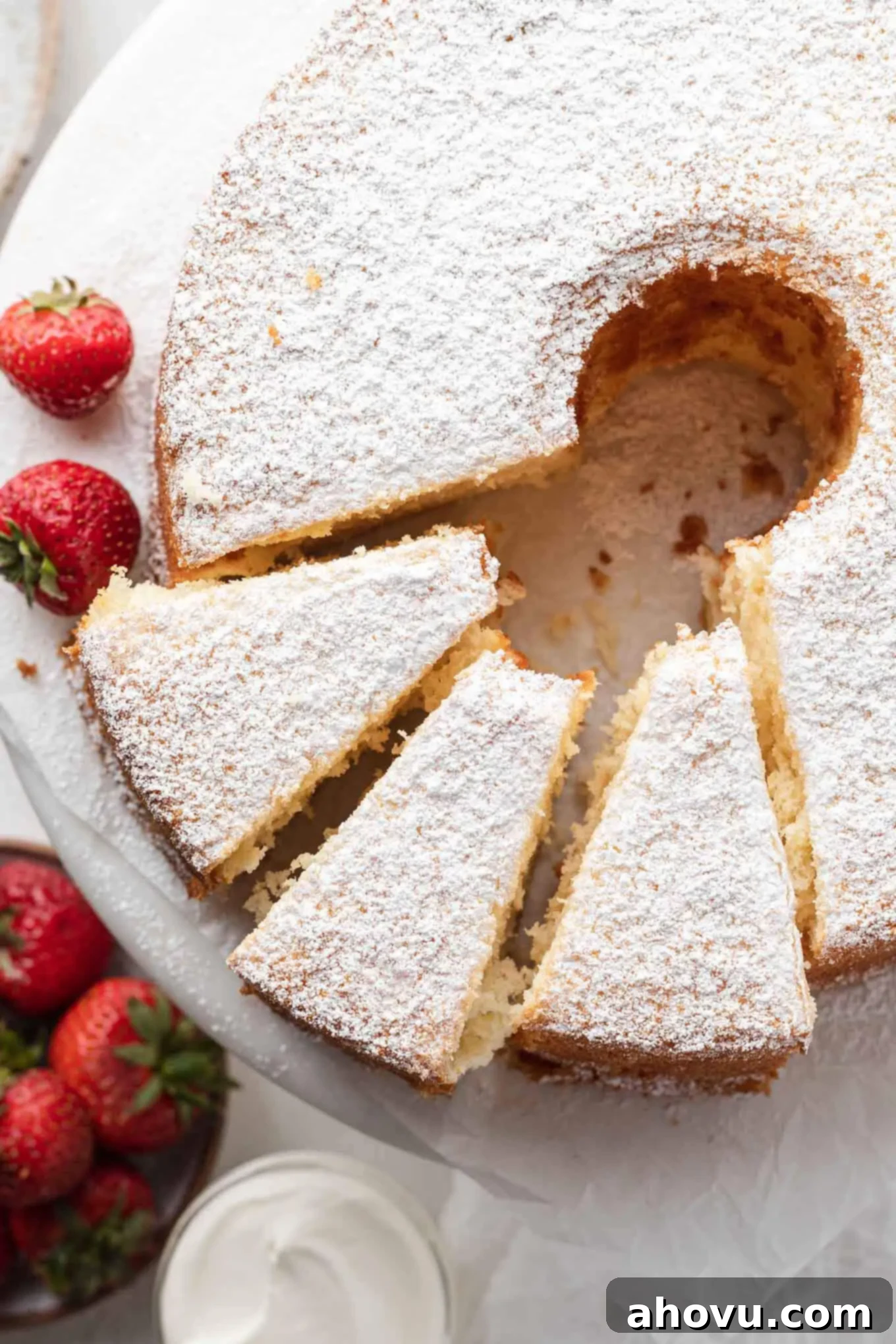 An inviting overhead shot of a freshly baked chiffon cake, beautifully golden, with three perfect slices already cut, revealing its airy and tender texture.