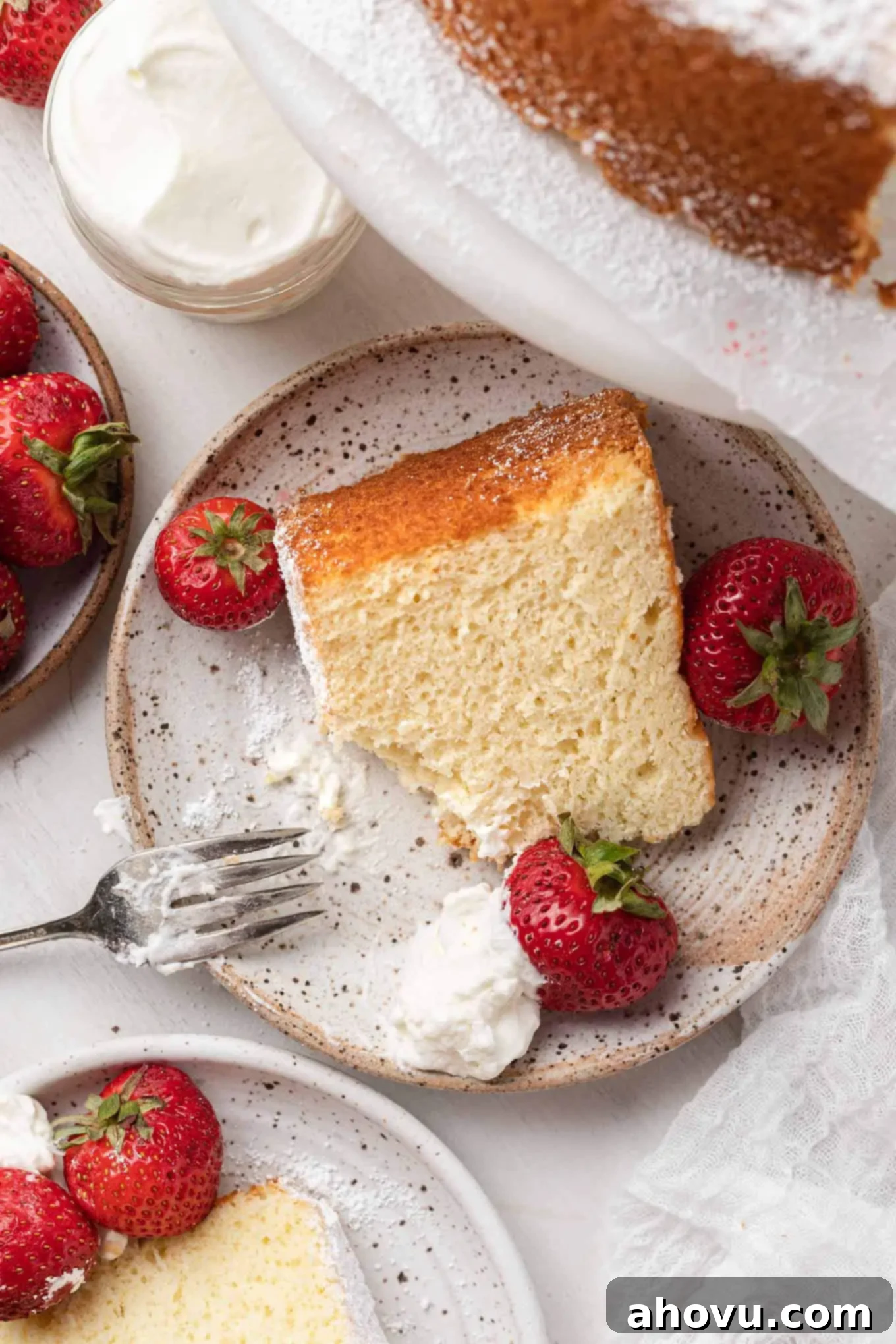 An aesthetic overhead view of individual chiffon cake slices, generously topped with fluffy whipped cream and vibrant fresh berries, ready to be savored.
