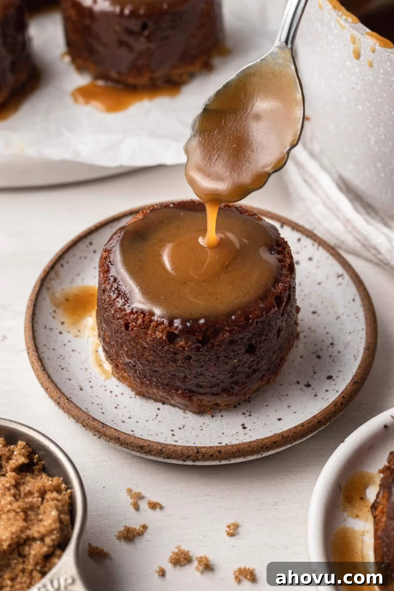 Warm Sticky Toffee Bliss 5 Toffee sauce being spooned over a sticky toffee pudding.