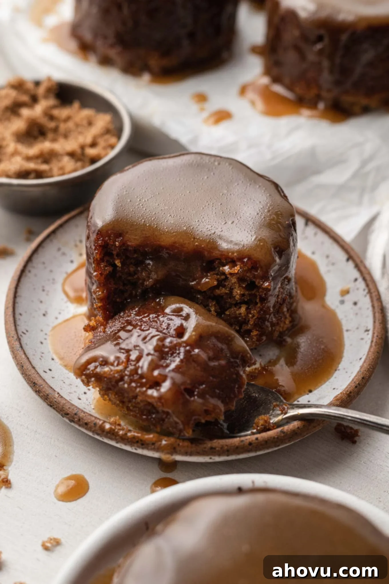 Warm Sticky Toffee Bliss 6 A forkful of sticky toffee pudding on a plate.