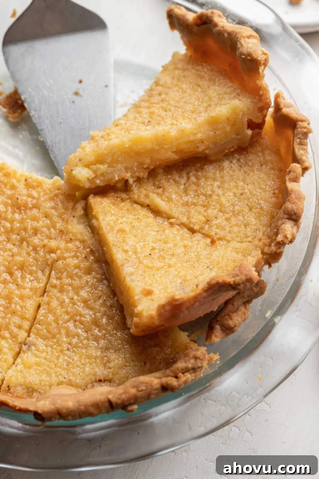 A sliced buttermilk pie in a glass pie plate.