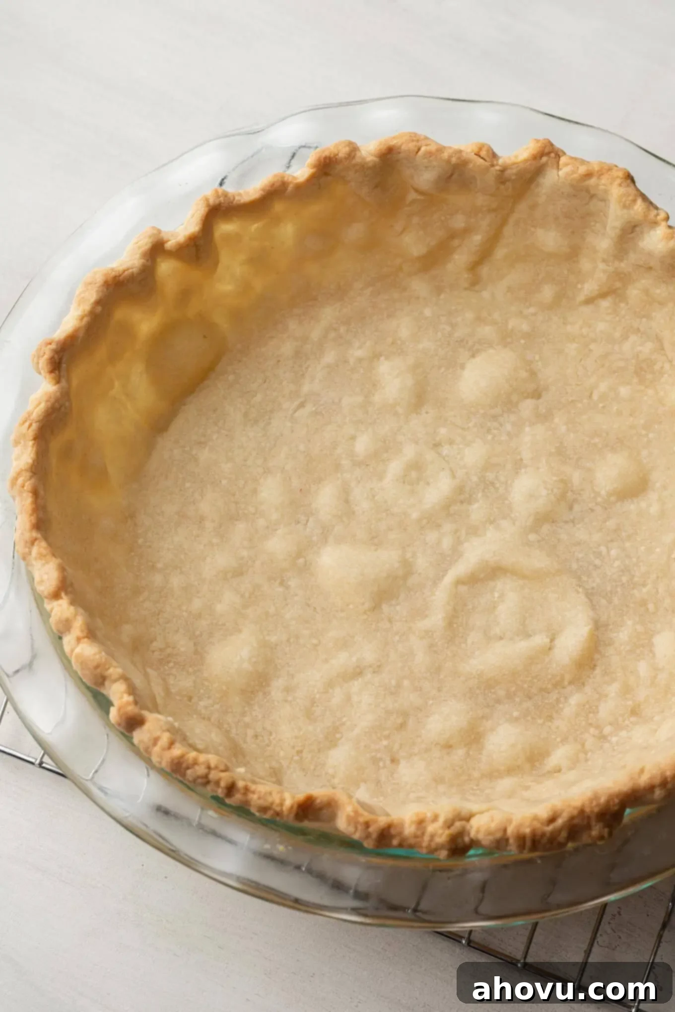 Heirloom Chocolate Pie 4 A perfectly blind-baked pie crust, golden brown and crisp, sitting ready in a clear glass pie plate, awaiting its rich chocolate filling.