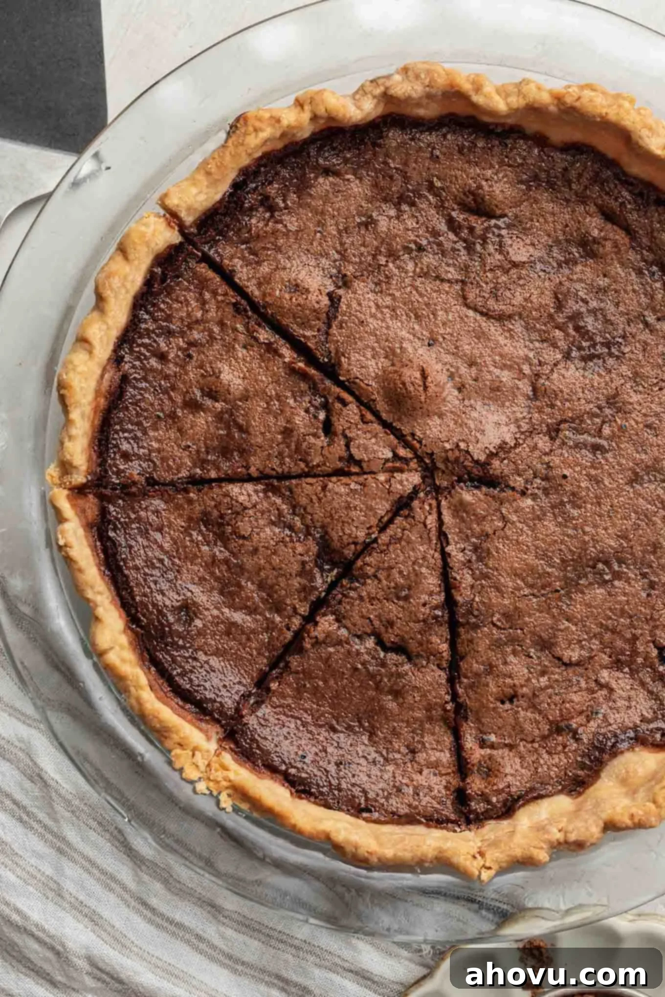 Heirloom Chocolate Pie 6 An inviting overhead view of a whole, baked chocolate chess pie, with three perfect slices already cut, revealing the rich, dark and fudgy filling.
