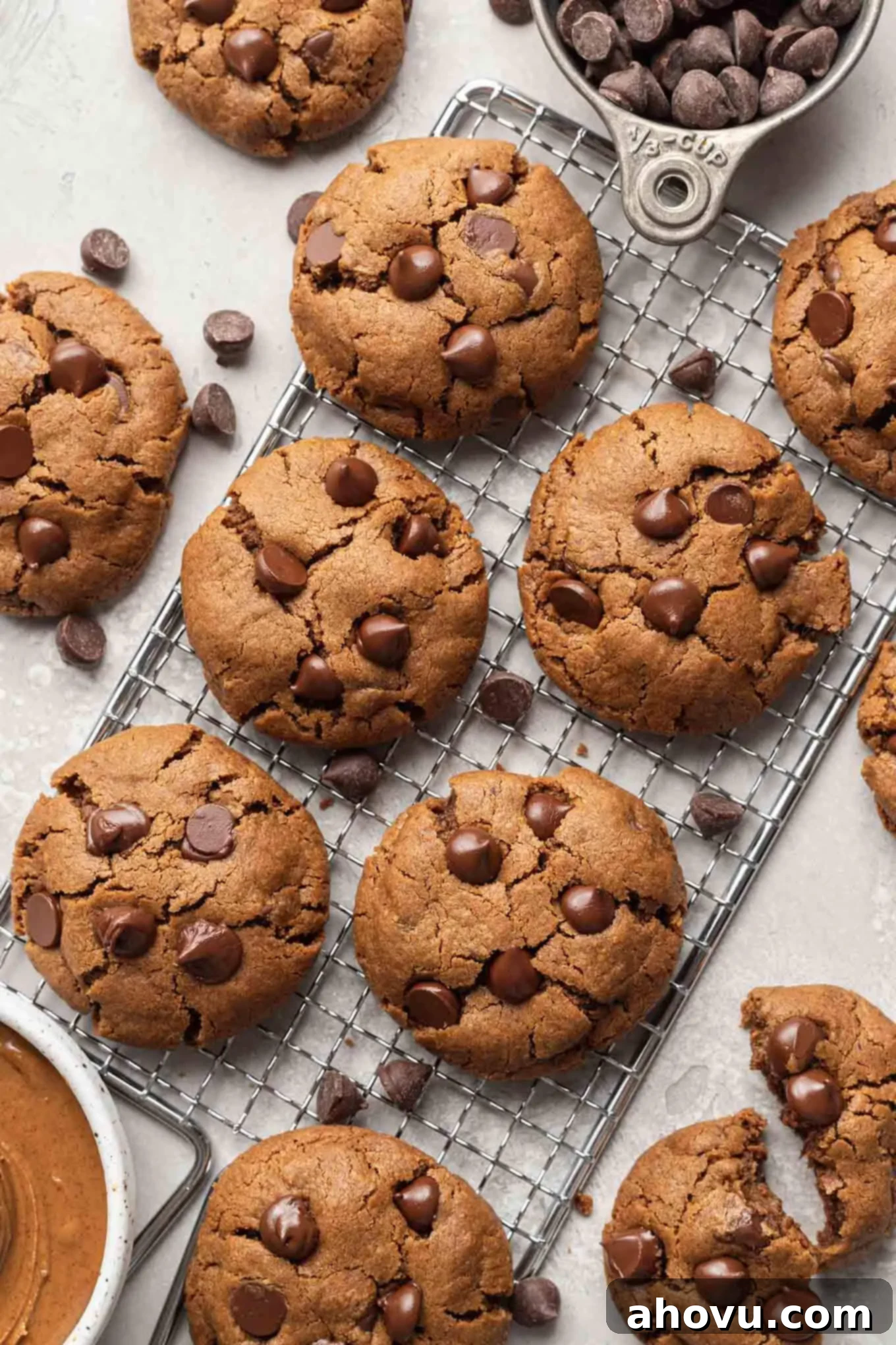 An overhead view of chocolate chip almond butter cookies on a wire rack. 