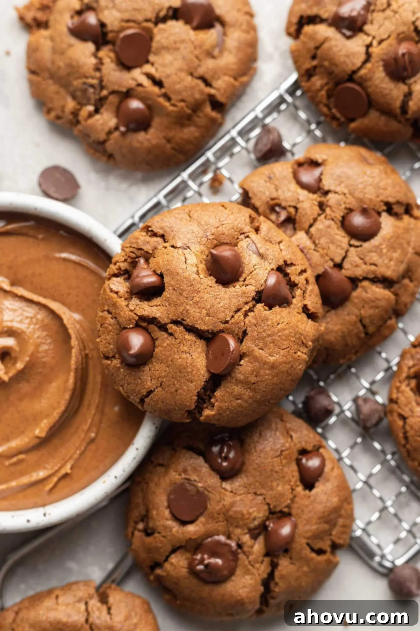 An overhead view of almond butter cookies, next to a bowl of almond butter. 