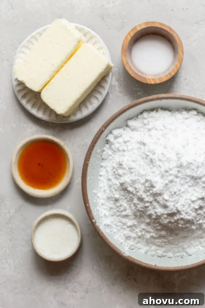 The ingredients needed to make a batch of buttercream frosting laid out in dishes on a gray surface.