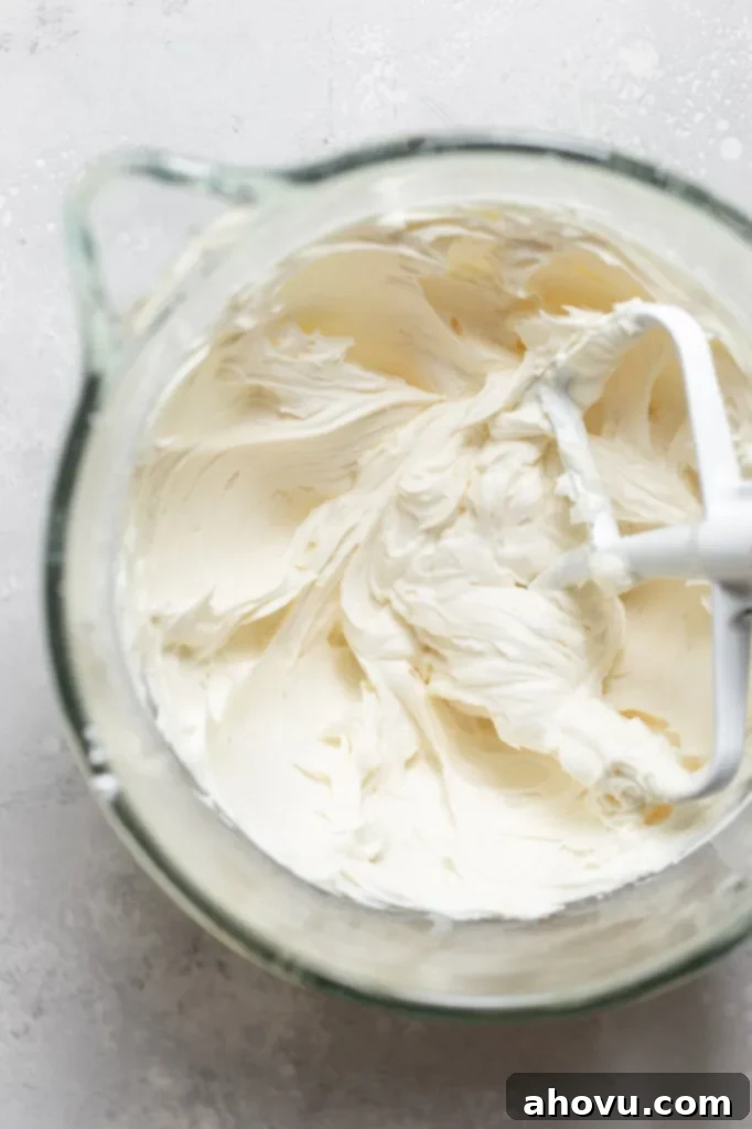 A glass mixing bowl holding a finished batch of buttercream frosting.