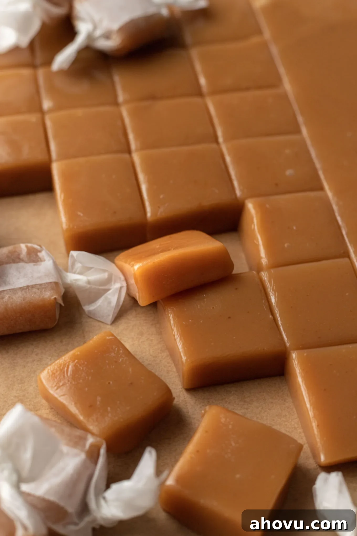 Homemade caramel candies sliced on a piece of parchment paper.