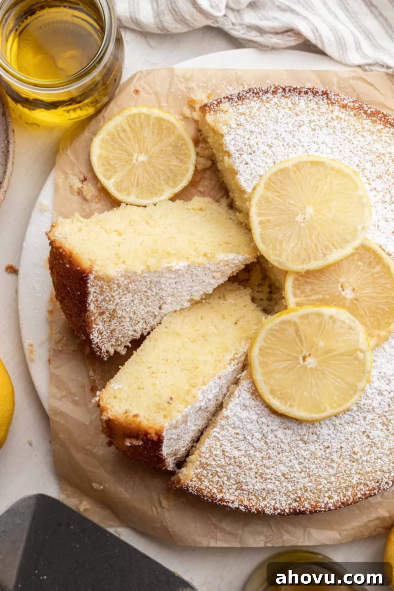 Sun-Kissed Lemon Olive Oil Cake 2 An overhead view of a lemon olive oil cake, with two slices turned on their sides.