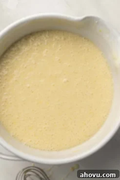 Lemon olive oil cake batter in a white ceramic mixing bowl.