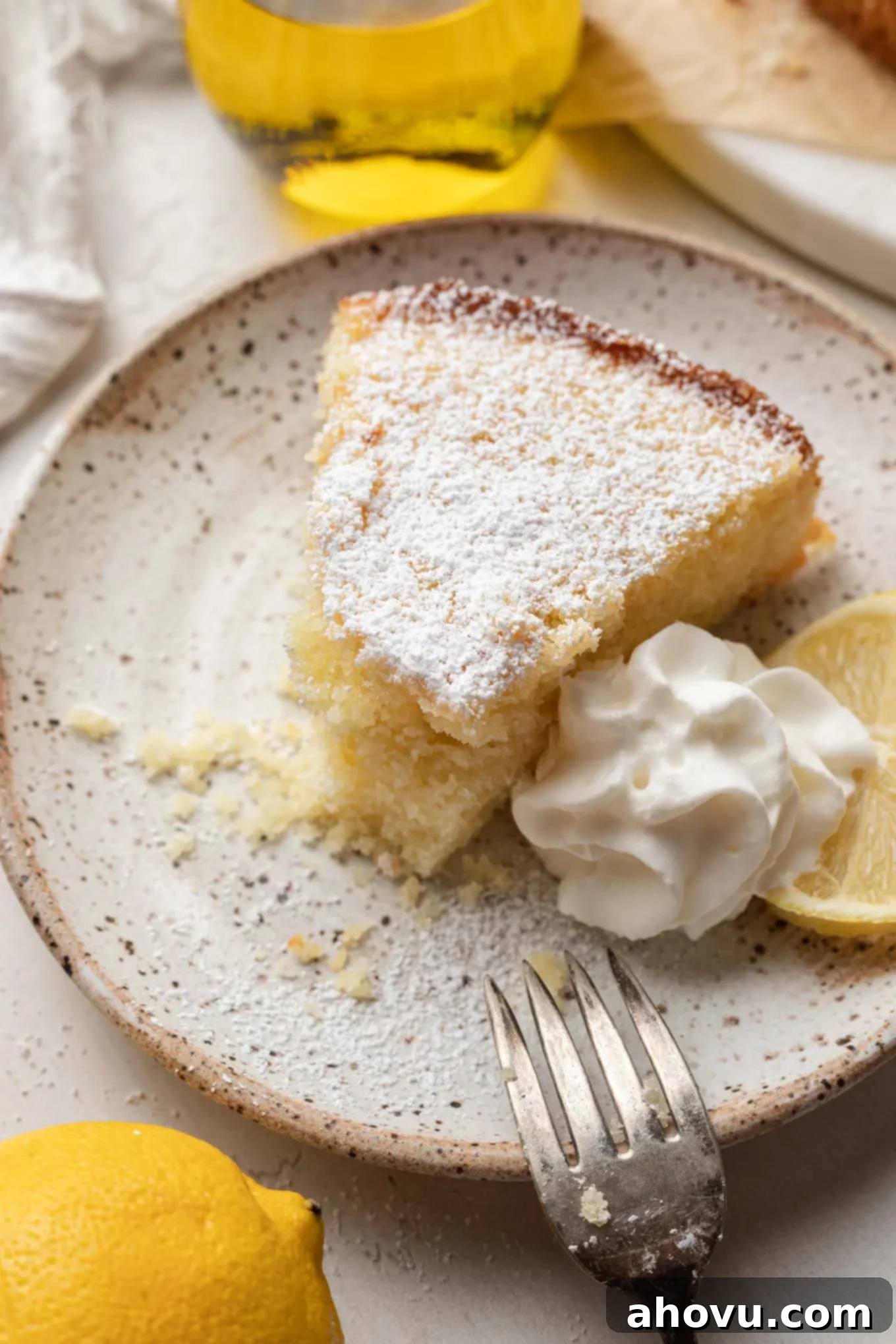 Sun-Kissed Lemon Olive Oil Cake 6 A slice of olive oil lemon cake with a bite missing.