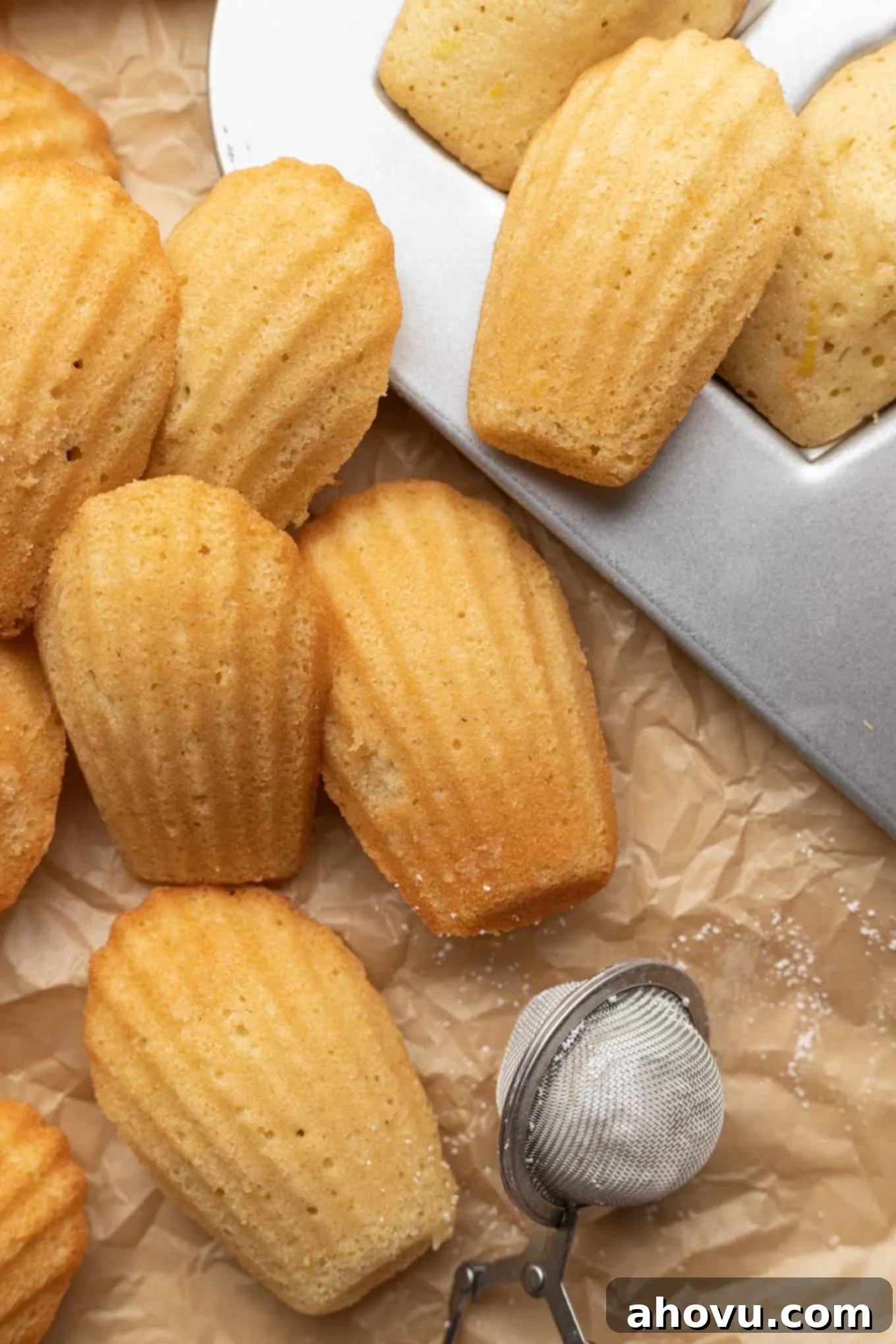 Golden Madeleines 5 Freshly baked French madeleines piled next to a madeleine baking pan.