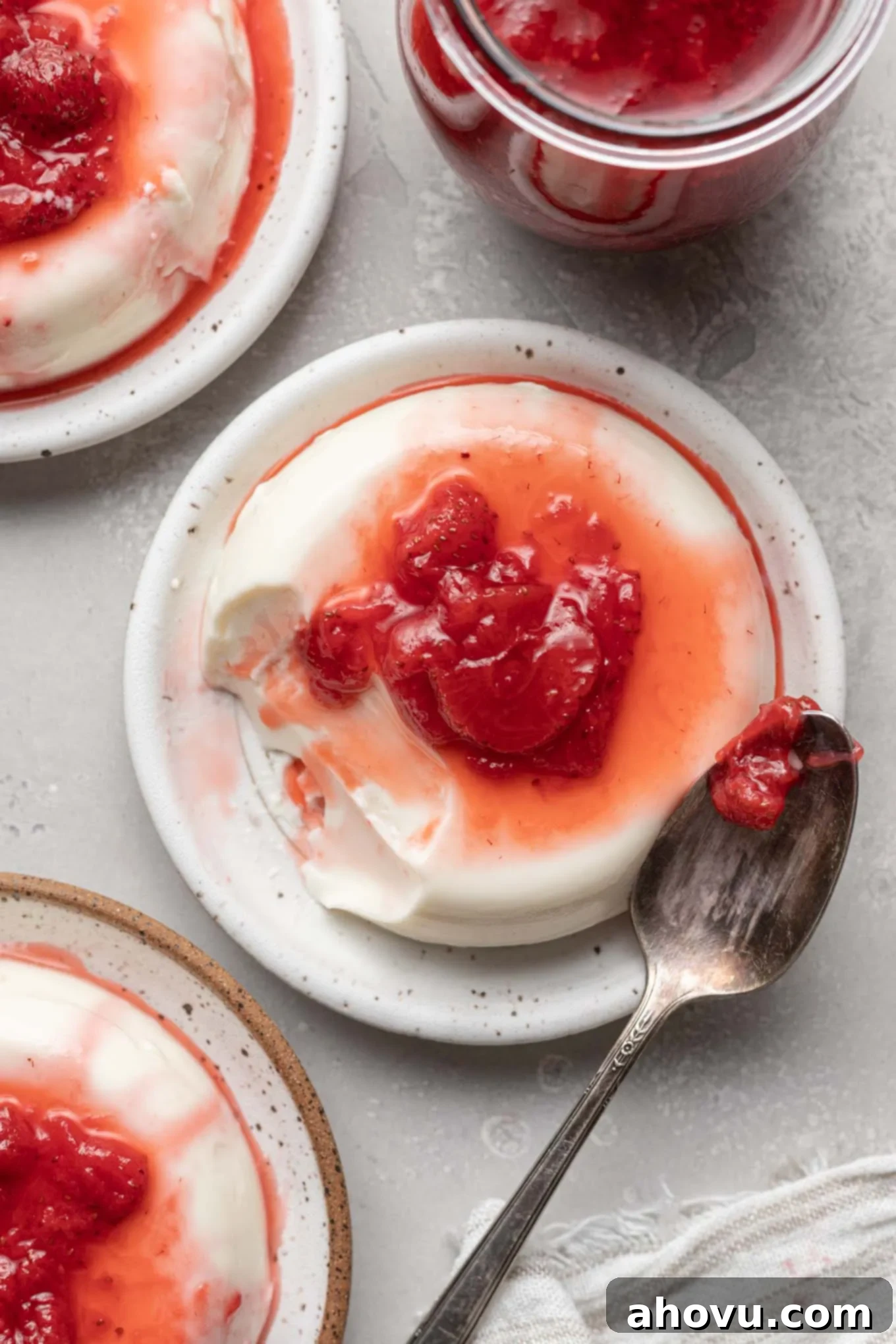 Silken Italian Indulgence 5 An overhead view of three strawberry panna cotta servings on small plates.