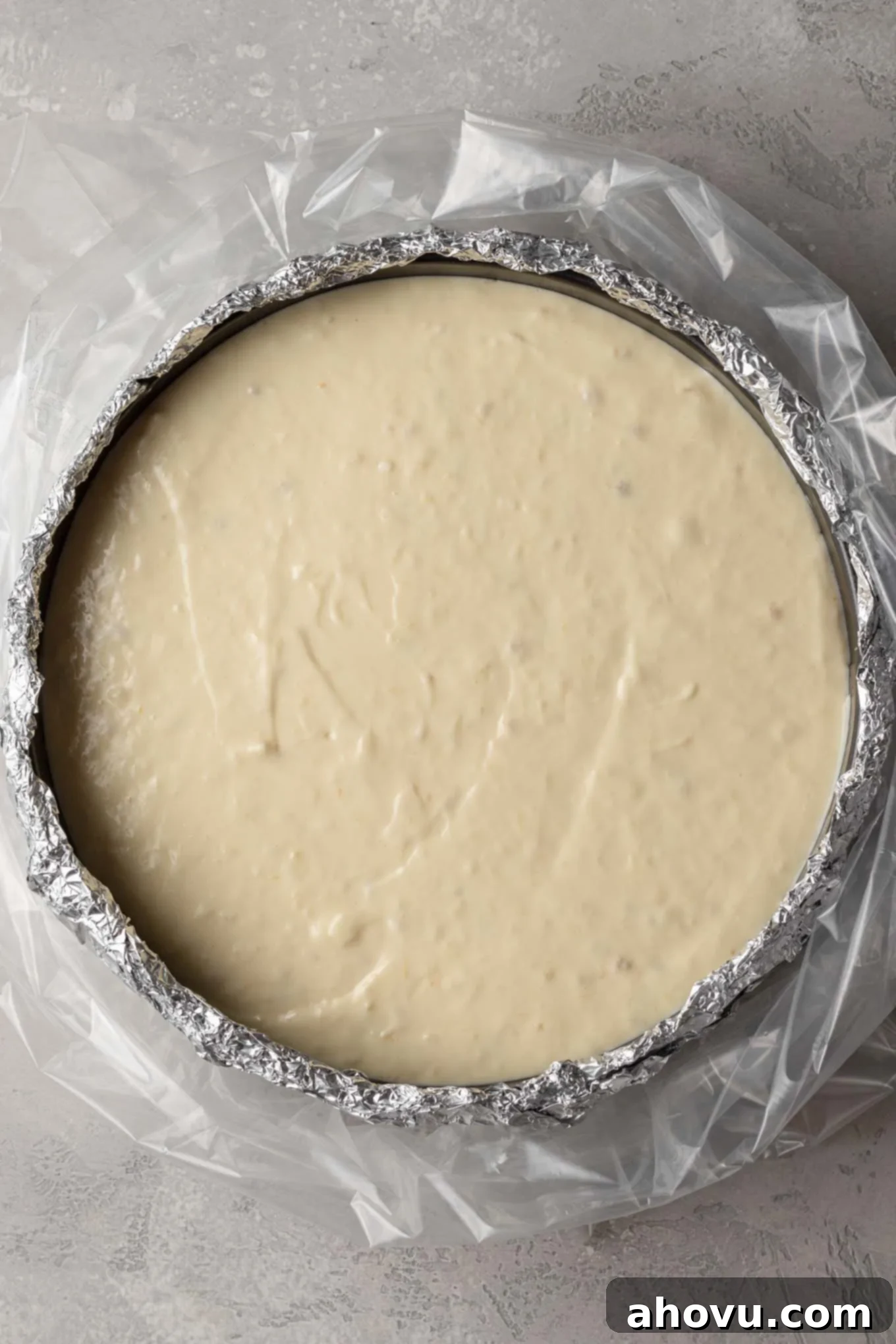 Banana Pudding Cheesecake 5 An overhead view of an unbaked cheesecake. The pan is wrapped in foil and placed in an oven bag.