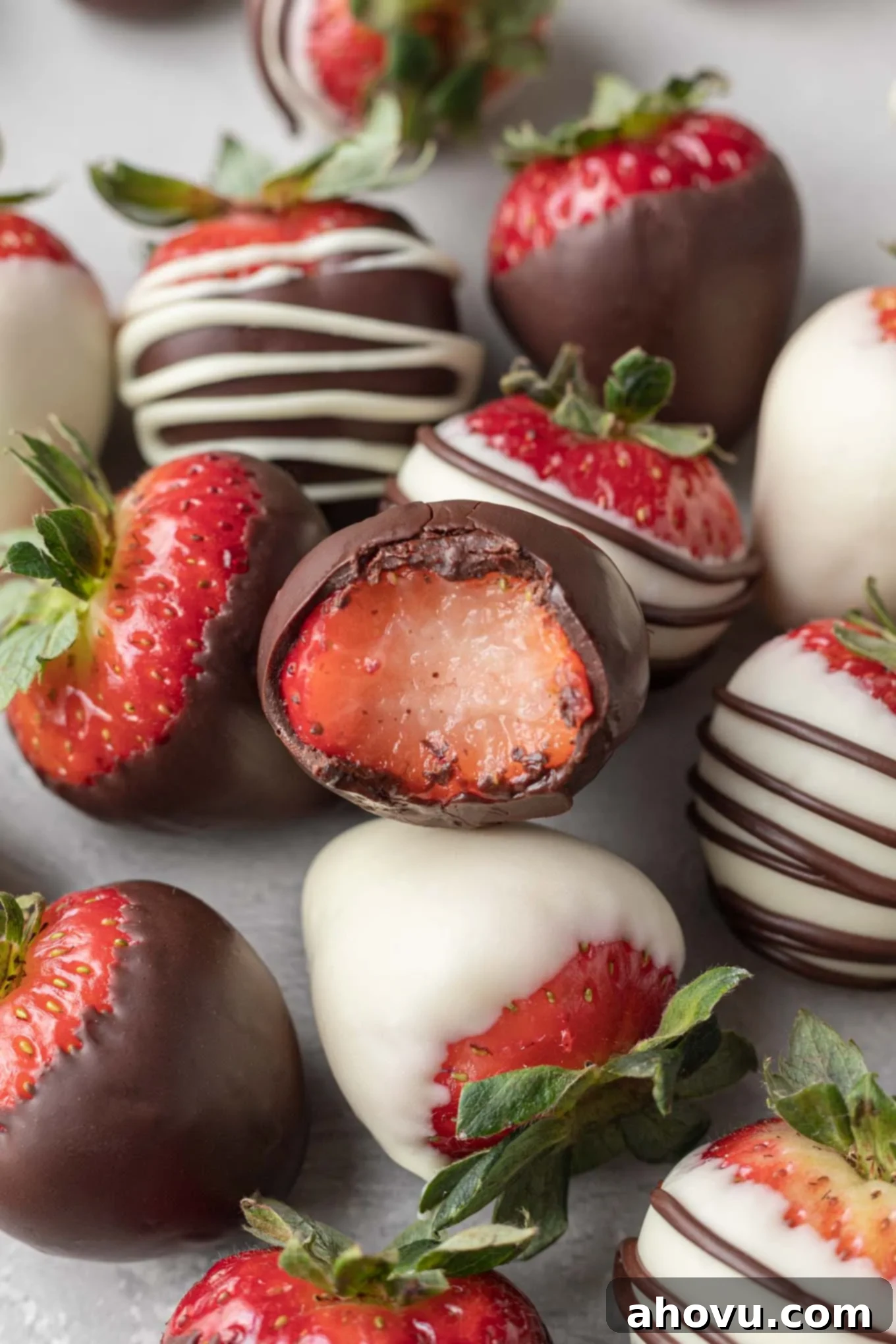 Luscious Chocolate Strawberries 6 Several chocolate covered strawberries on a piece of parchment paper. One strawberry has a bite taken out of it.