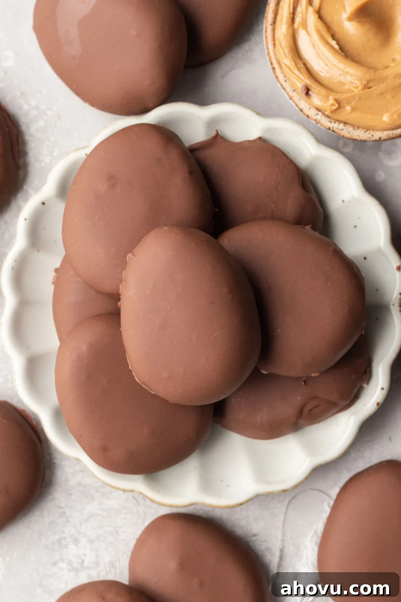 An overhead view of homemade peanut butter eggs on a white plate. 