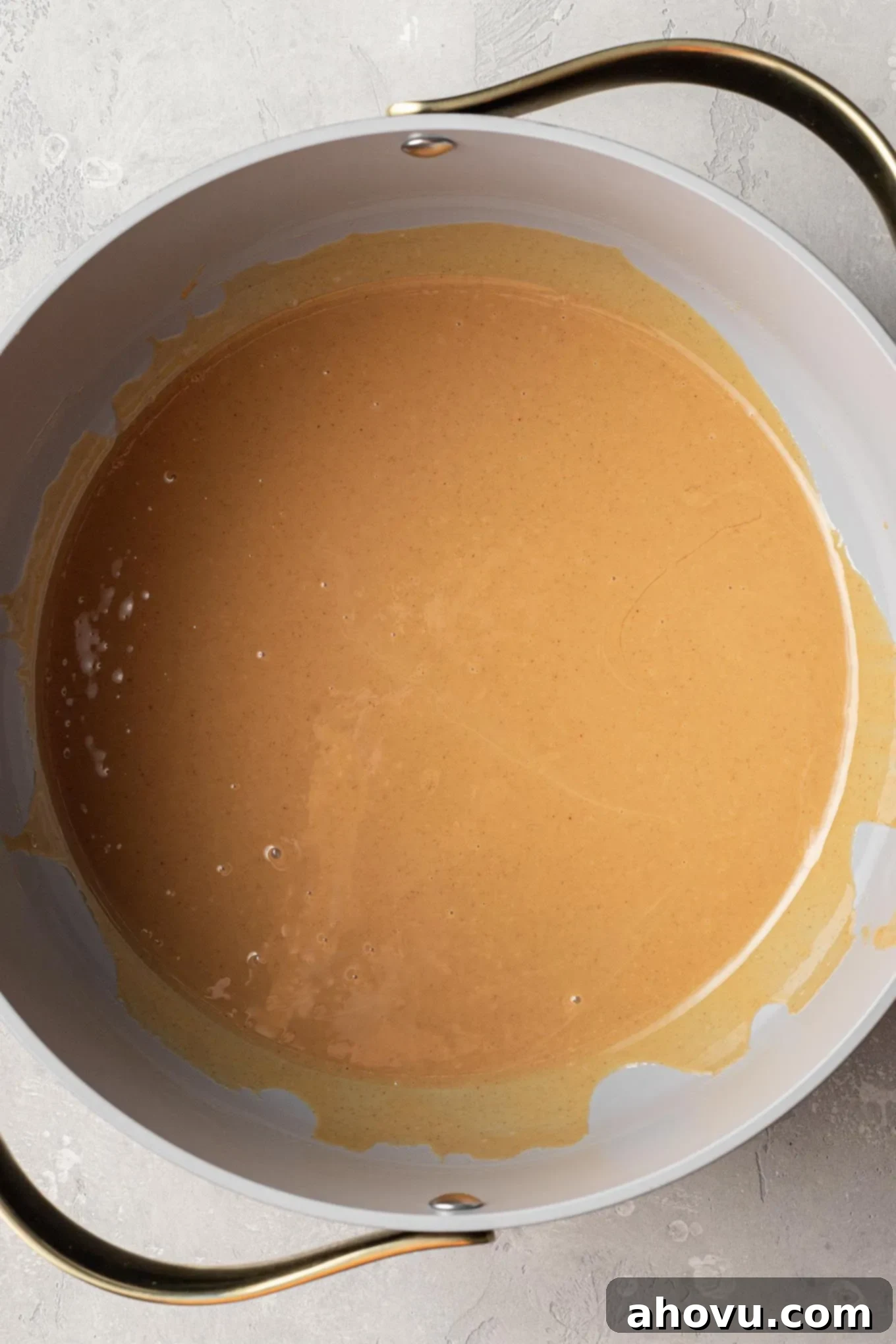 An overhead view of melted butter and peanut butter in a saucepan.