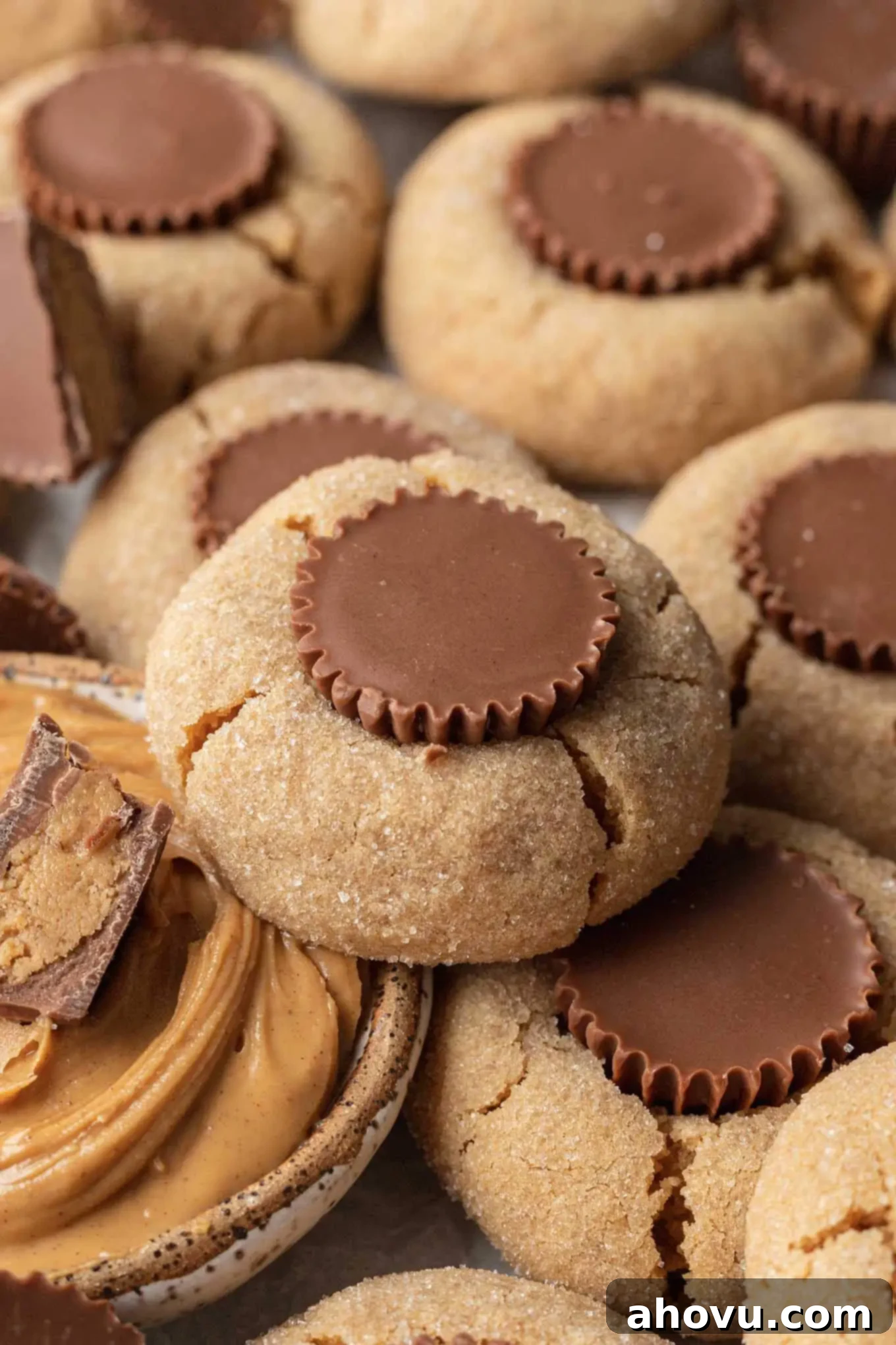 An array of peanut butter cookies with peanut butter cups, with a dish of peanut butter in the center. 
