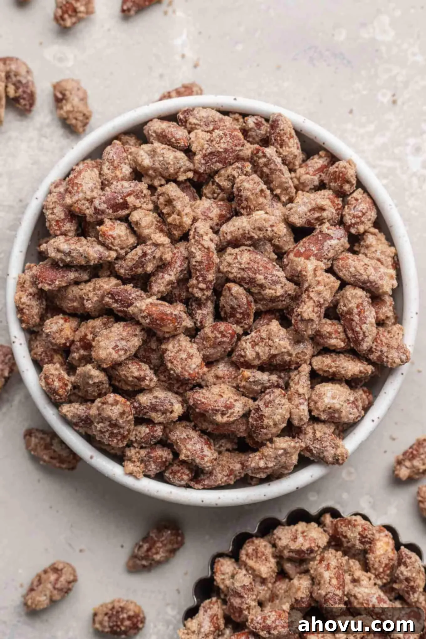 An overhead view of a bowl of candied almonds, showcasing their glossy, golden-brown coating and inviting texture.