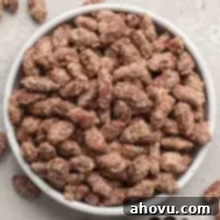 A beautifully presented white bowl overflowing with crunchy, sweet candied almonds, ready to be enjoyed.