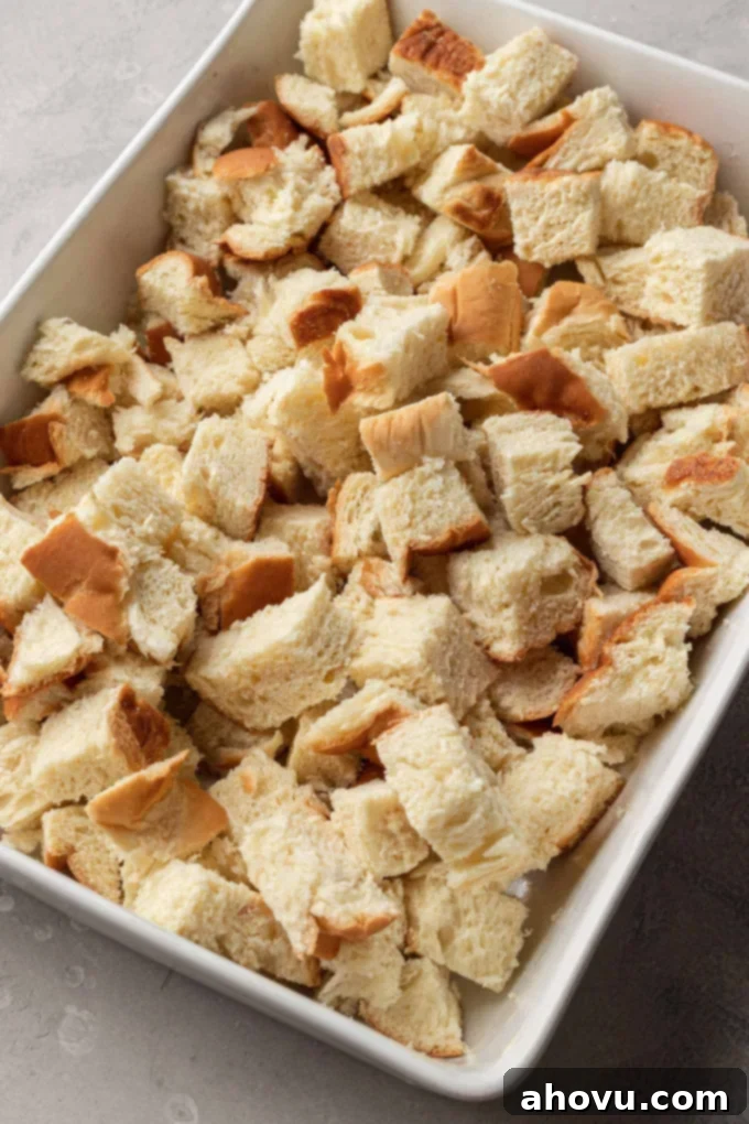 Sweet Morning French Toast Bake 4 Challah bread cubes in a white casserole dish.