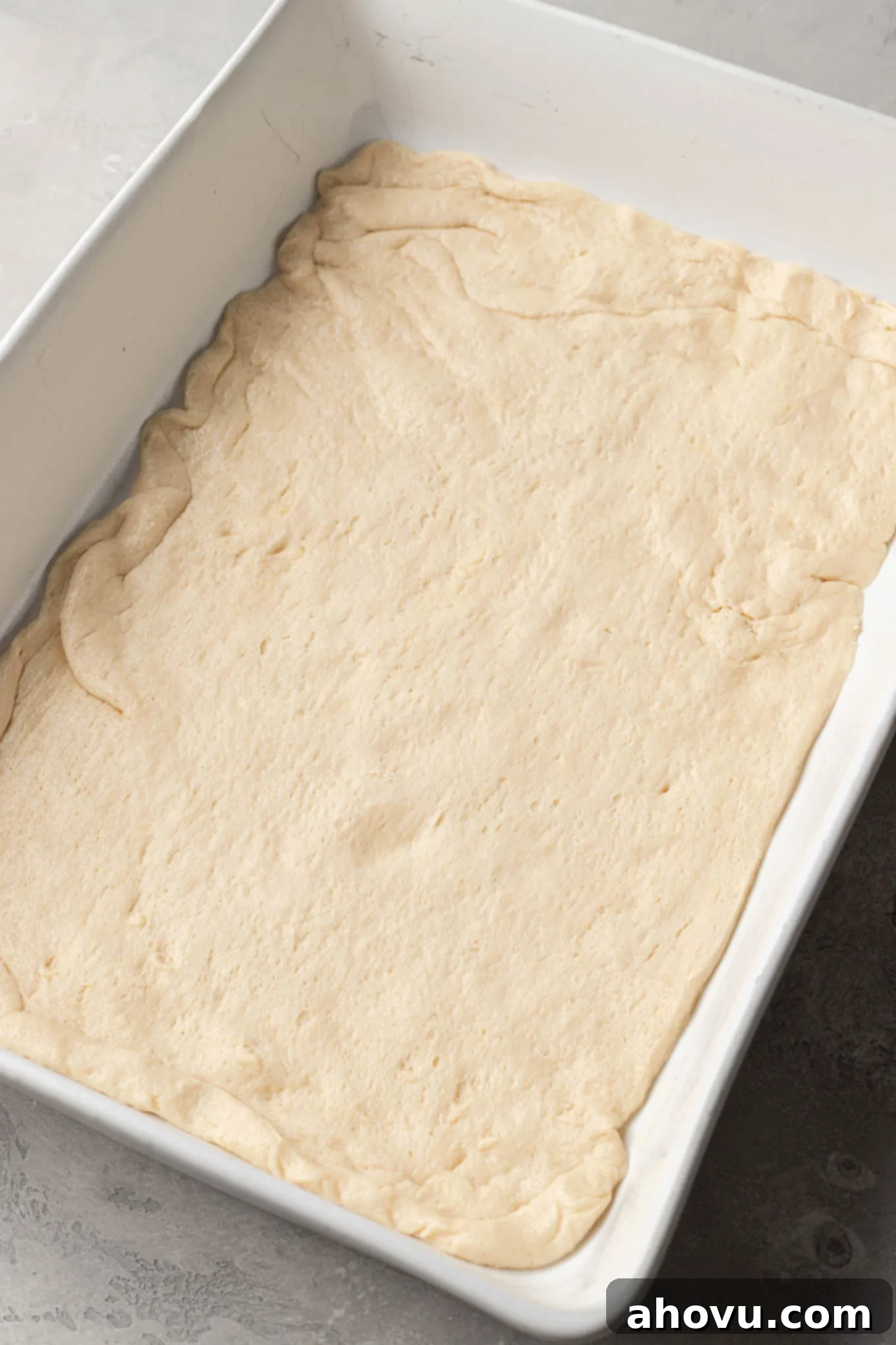 An overhead view of crescent roll dough stretched to cover the bottom of a 9x13-inch pan.
