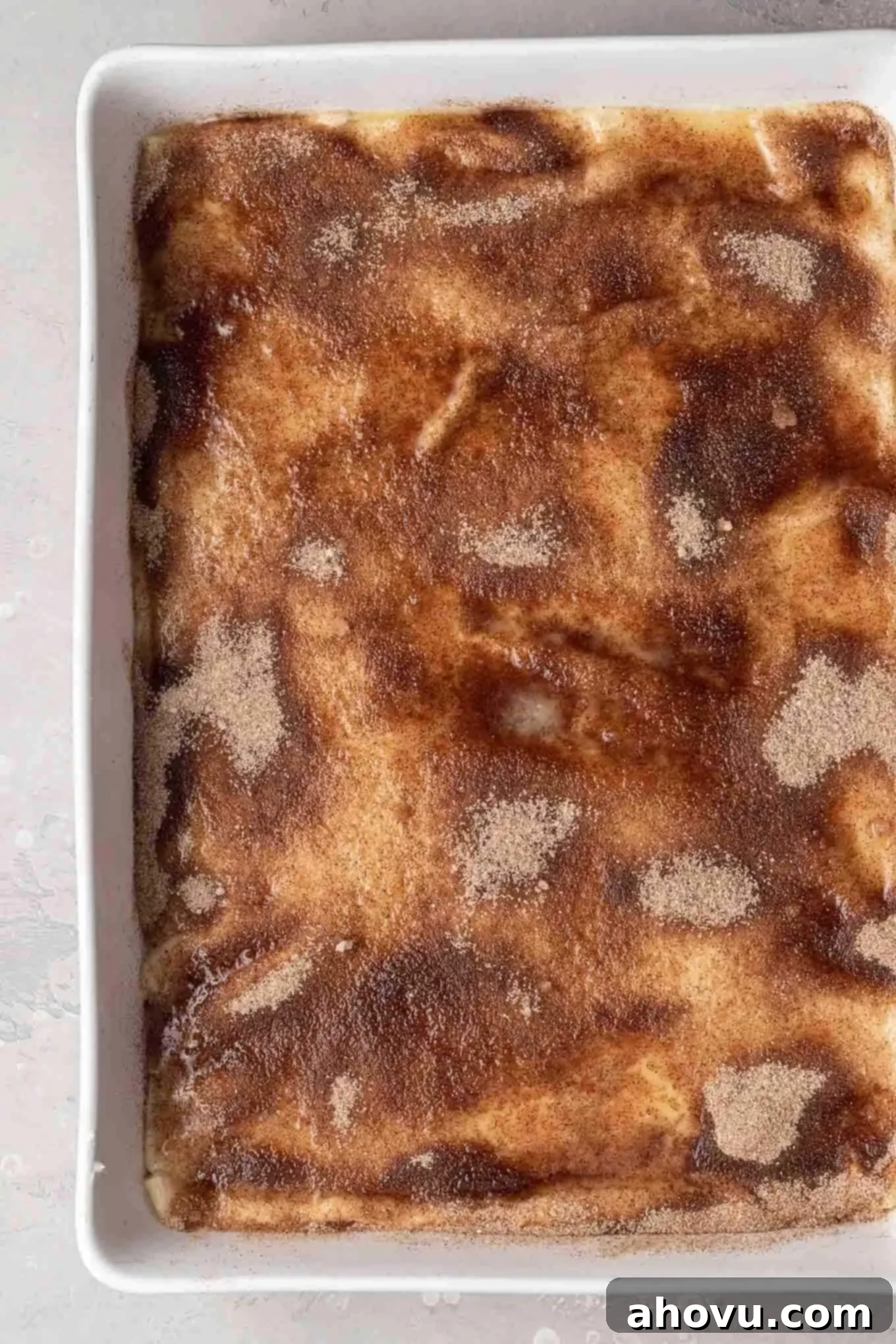 An overhead view of a cinnamon-sugar topped sopapilla cheesecake, ready to be baked.