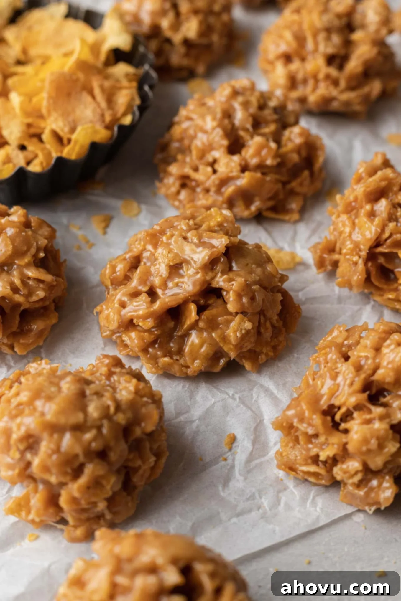 A close-up view of perfectly set no-bake cornflake cookies resting on parchment paper, showcasing their texture.