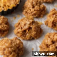 Several golden brown no-bake cornflake cookies resting on a piece of parchment paper, showcasing their inviting texture.