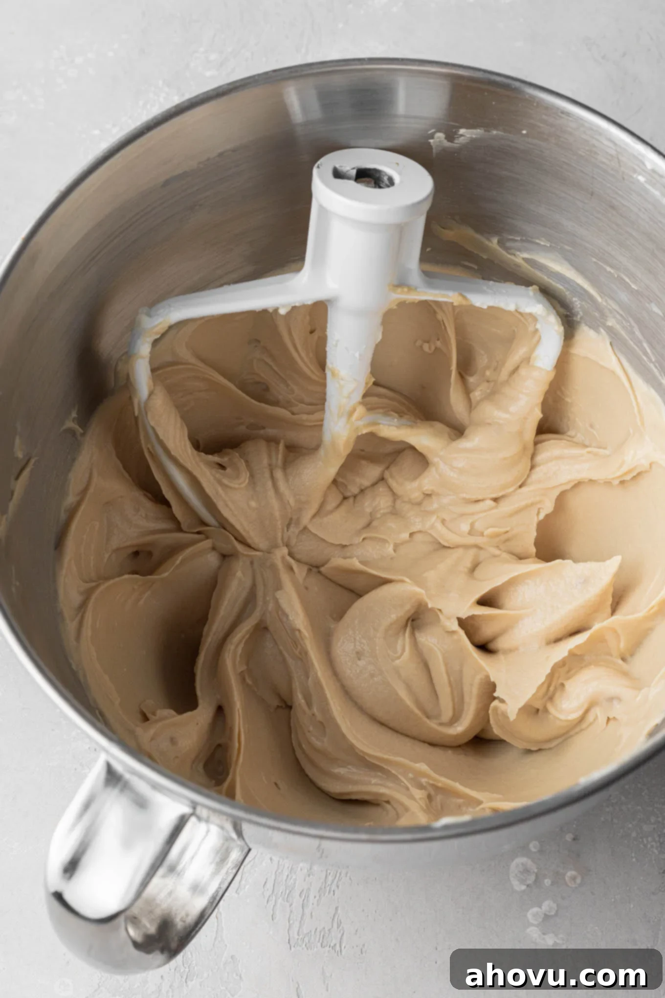 Dreamy Cookie Dough Dip 6 An overhead view of edible cookie dough dip mixture in a mixing bowl. A paddle attachment rests in the bowl.